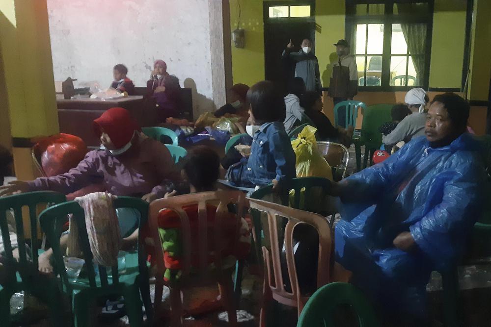 Aldeanos descansan en un refugio temporal después de dejar sus hogares luego de la erupción del volcán Semeru, en Java, Indonesia, el 4 de diciembre de 2021. (Foto AP/Rokhmad)