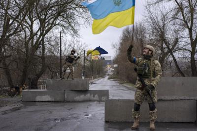 Un soldado ucraniano levanta una bandera de su país en Bucha, en las afueras de Kiev, el 3 de abril del 2022. Rusia sufrió un revés de proporciones históricas al no poder tomar la capital de Ucrania. (AP Photo/Rodrigo Abd, File)