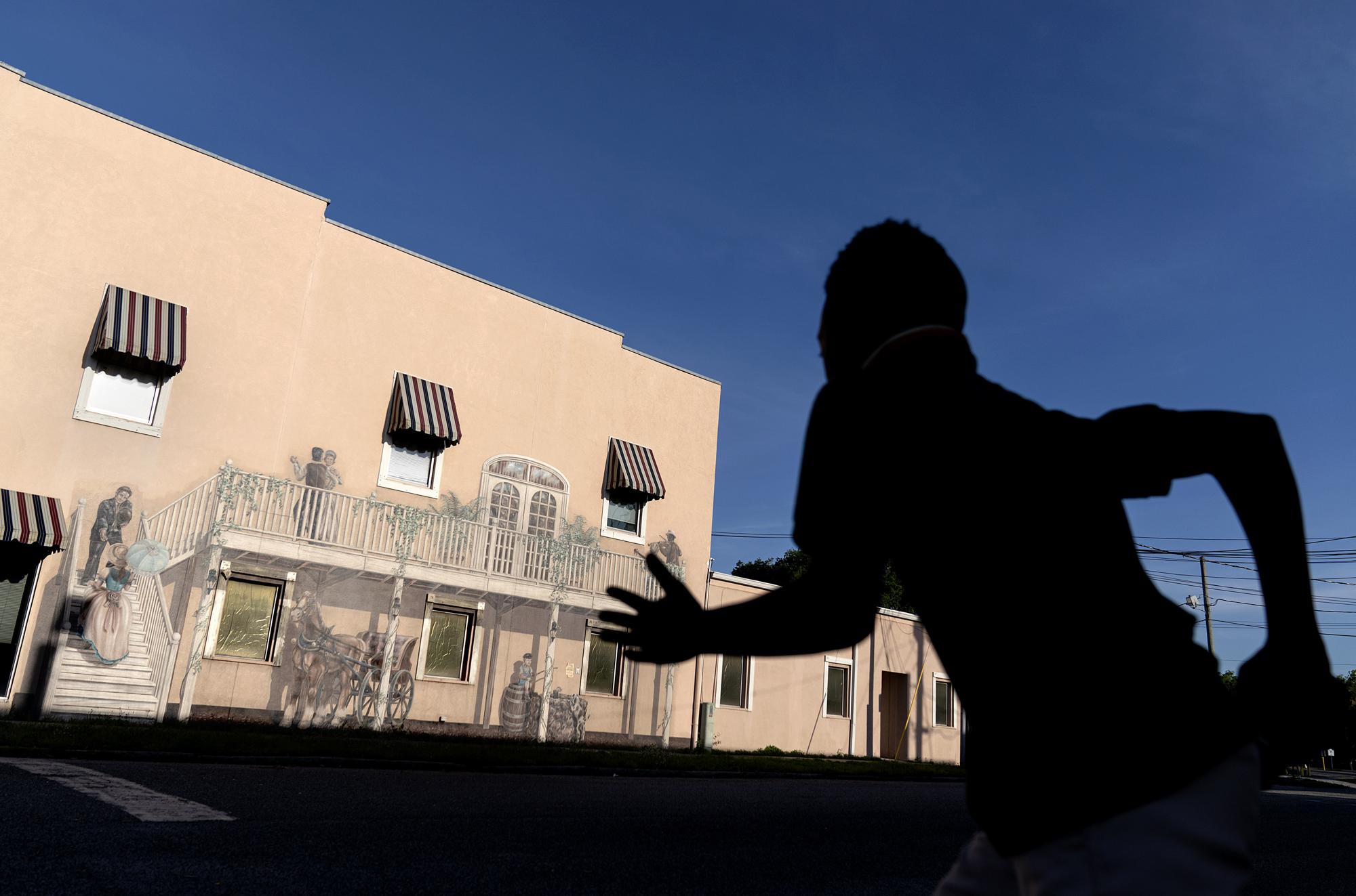 A mural titled "Bygone Days" decorates a downtown building as a child rushes to cross a street in Palatka, Fla., Tuesday, April 13, 2021. Jim Crow Florida was one of the most dangerous places in the South to be Black. In that era, a Black man in Florida was more at risk of being lynched - an execution without trial, often by gun or hanging - than in any other state, according to a University of Georgia study of lynching records. (AP Photo/David Goldman)