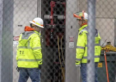 A Tacoma Power crew works at an electrical substation damaged by vandals early on Christmas morning, Sunday, Dec. 25, 2022 in Graham, Wa. (Ken Lambert/The Seattle Times via AP)