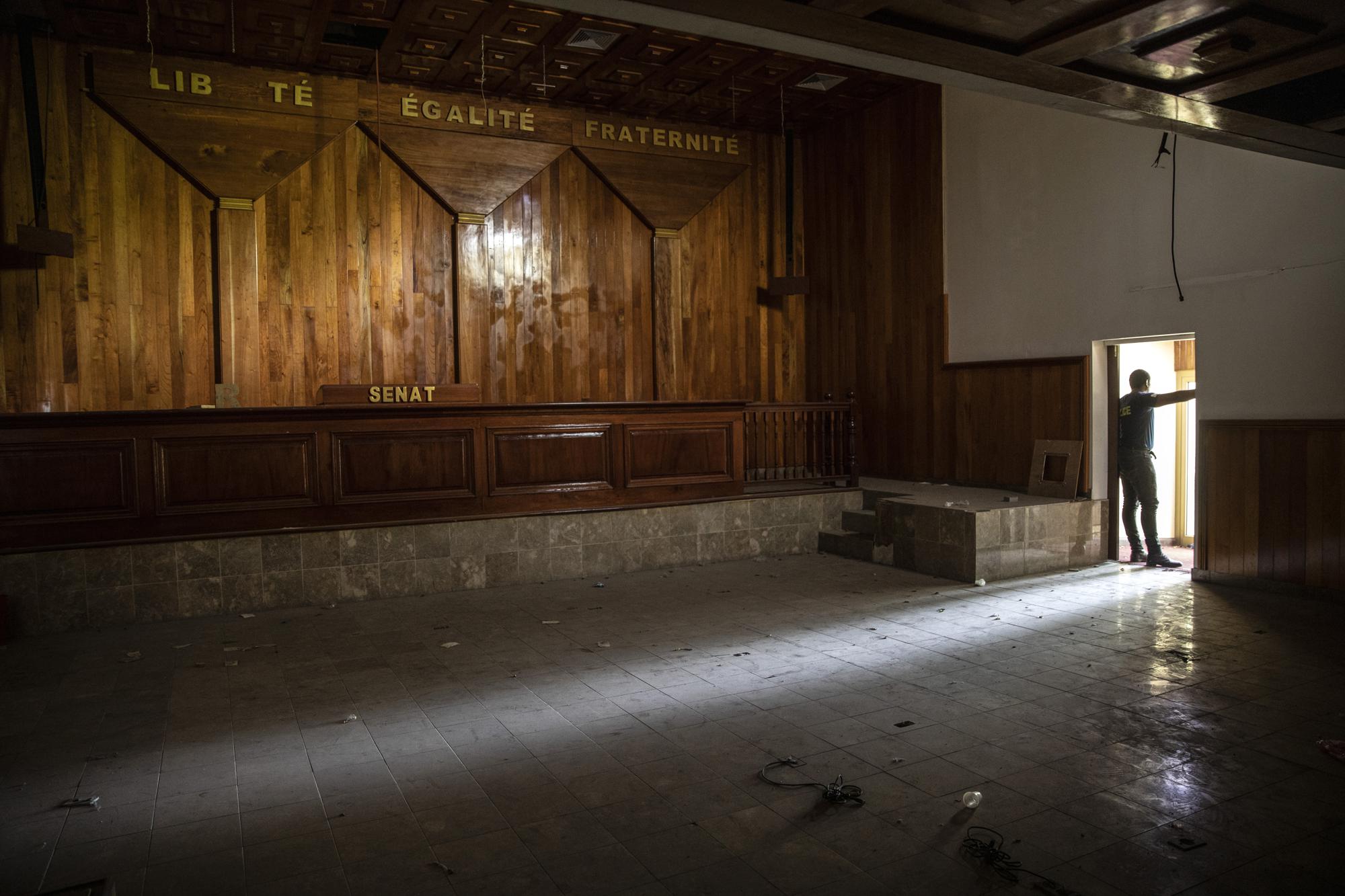 A policeman stands in the entrance of the deserted Senate chambers, inactive for over a year, in Port-au-Prince, Haiti, Tuesday, Sept. 22, 2021. The country has struggled with political instability — along with dire poverty and crime — since the end of the brutal dictatorships of Francois and Jean-Claude Duvalier from 1957 to 1986. (AP Photo/Rodrigo Abd)