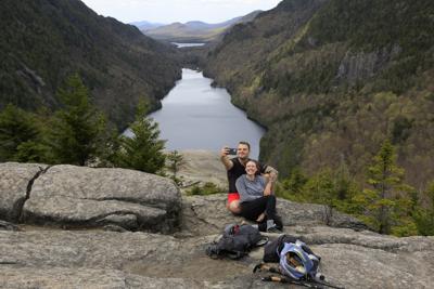 Sidney Gleason, derecha, y Joe Gorsuch se toman una selfie frente al lago Lower Ausable en la Reserva de los Montes Adirondack, Nueva York, 15 de mayo de 2021. (AP Foto/Julie Jacobson)