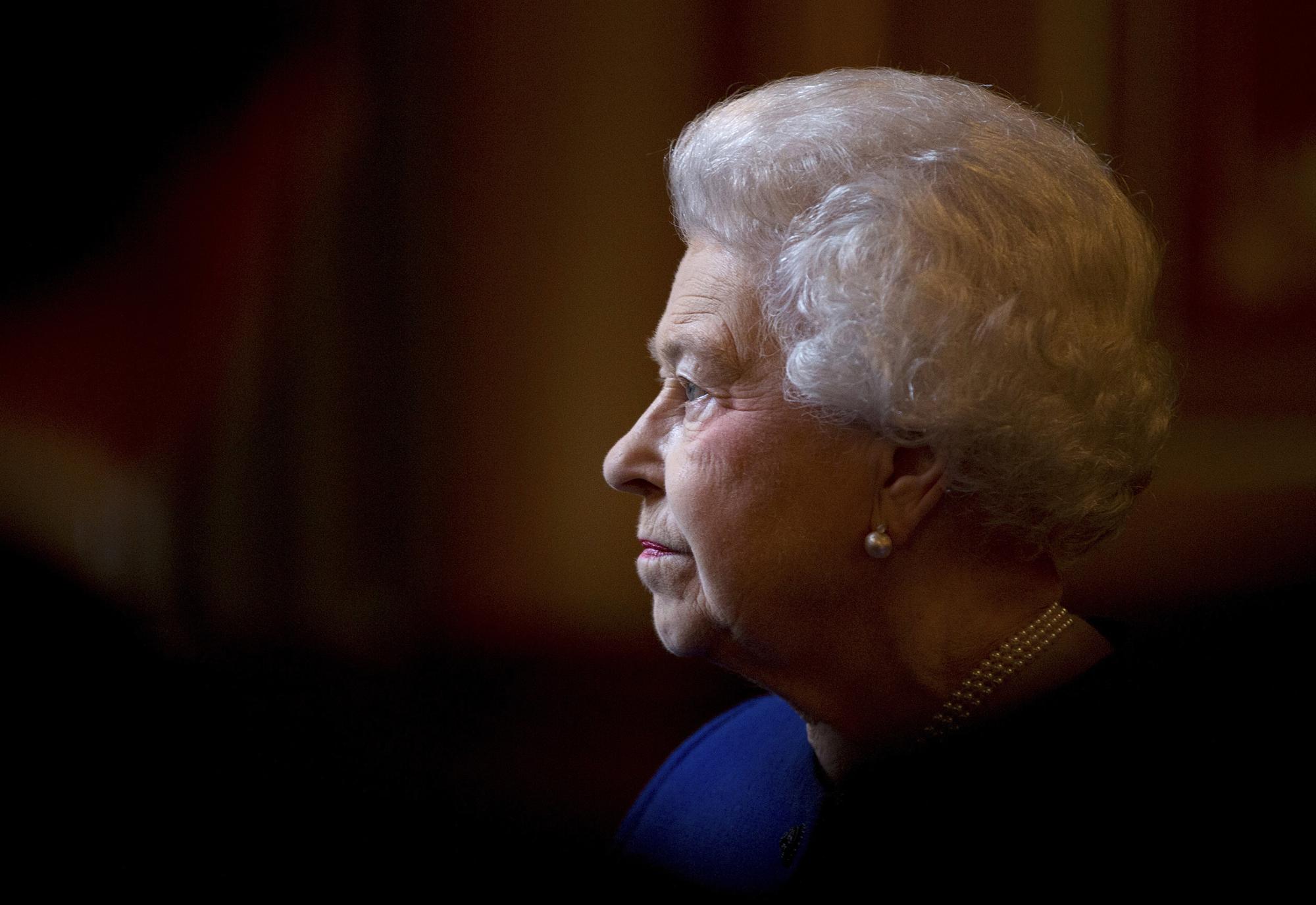FILE - Britain's Queen Elizabeth II escorted by British Foreign Secretary William Hague, tours the Foreign and Commonwealth Office during an official visit which is part of her Jubilee celebrations in London, Tuesday, Dec. 18, 2012.  Queen Elizabeth II will mark 70 years on the throne Sunday, Feb. 6, 2022, an unprecedented reign that has made her a symbol of stability as the United Kingdom navigated an age of uncertainty. (AP Photo/Alastair Grant, Pool, File)