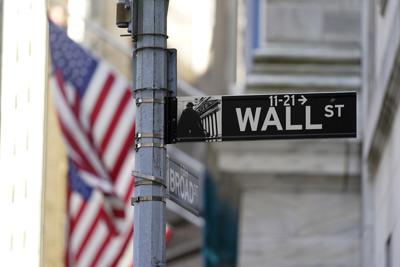 Fotografía de archivo del 16 de junio de 2021 de banderas ondeando en la fachada de la Bolsa de Valores de Nueva York, atrás de un letrero con el nombre de su calle. (AP Foto/Richard Drew)