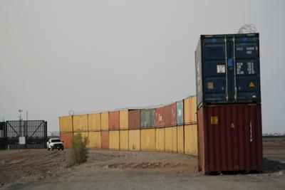 ARCHIVO - Agentes de la Patrulla Fronteriza realizan labores de vigilancia a lo largo de una hilera de contenedores de envío apilados cerca de la frontera, el 23 de agosto de 2022, cerca de Yuma, Arizona. (AP Foto/Gregory Bull, archivo)