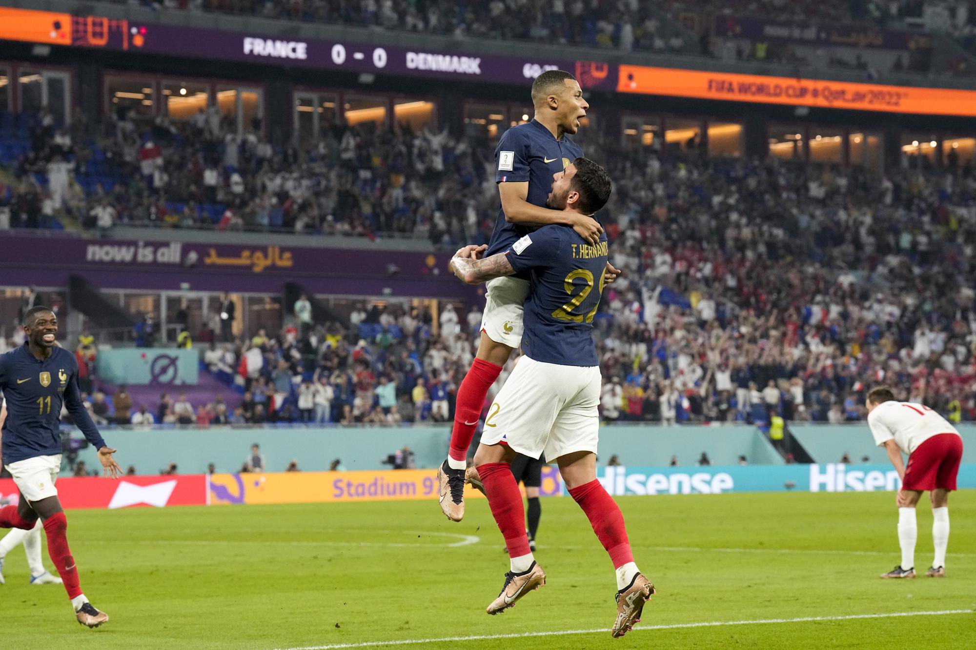 France's Kylian Mbappe celebrates with teammate Theo Hernandez after scoring his side's opening goal against Denmark during a World Cup group D soccer match at the Stadium 974 in Doha, Qatar, Saturday, Nov. 26, 2022. (AP Photo/Martin Meissner)