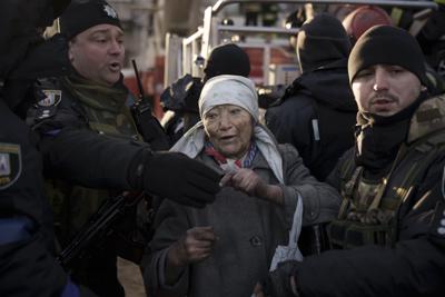 Una anciana es ayudada por policías después de que fue rescatada por los bomberos del interior de su apartamento después de un bombardeo en Kiev, Ucrania, el martes 15 de marzo de 2022. La ofensiva de Rusia en Ucrania se ha acercado al centro de Kiev con una serie de ataques que golpearon un vecindario residencial mientras los líderes de tres países miembros de la Unión Europea planeaban una visita a la asediada capital de Ucrania. (AP Foto/Felipe Dana)