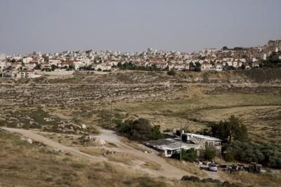 FILE - A Palestinian home sits in a valley, next to the east Jerusalem Jewish Israeli settlement of Pisgat Ze'ev, May 12, 2022. Investigators commissioned by the U.N.-backed Human Rights Council said Tuesday, June 7, 2022, that tensions between Palestinians and Israelis are underpinned by a feeling that Israel has embarked on a “perpetual occupation” of Palestinian areas with no intention of ending it. The findings came Tuesday in the first report by a Commission of Inquiry, set up last year following an 11-day war between Israel and Hamas in Gaza. (AP Photo/Maya Alleruzzo, File)