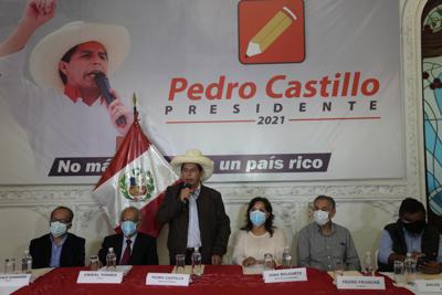 El candidato presidencial Pedro Castillo habla durante una conferencia de prensa junto a su compañera de fórmula Dina Boluarte, tercera desde la derecha, en la sede de su campaña en Lima, Perú, el martes 15 de junio de 2021. (AP Foto/Martín Mejía)