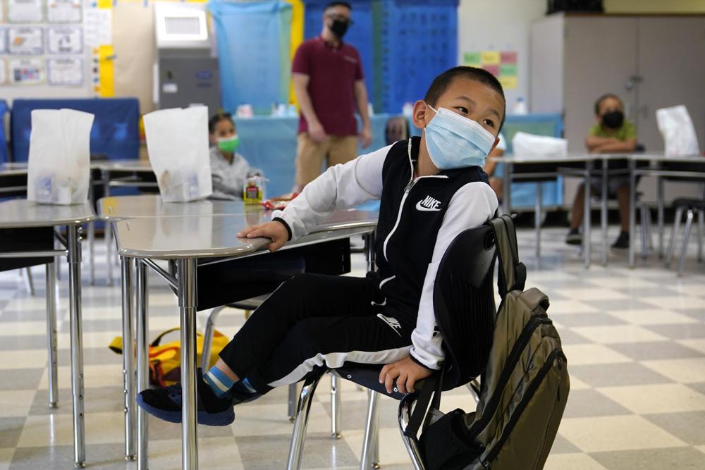 A summer school student wears a protective mask in class at the E.N. White School in Holyoke, Mass., on Wednesday, Aug. 4, 2021. Schools across the U.S. are about to start a new year amid a flood of federal money larger than they've ever seen before, an infusion of pandemic relief aid that is four times the amount the U.S. Department of Education sends to K-12 schools in a typical year. (AP Photo/Charles Krupa)