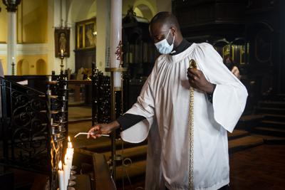 Velas son encendidas durante un servicio para el arzobispo anglicano Desmond Tutu en la catedral de St. Mary en Johannesburgo, el martes 28 de diciembre de 2021. (AP Foto/Shiraaz Mohamed).