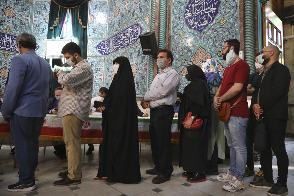 Voters queue at a polling station during the presidential elections in Tehran, Iran, Friday, June 18, 2021. Iranians voted Friday in a presidential election dominated by a hard-line protege of Supreme Leader Ayatollah Ali Khamenei after authorities disqualified nearly all of his strongest competition, leading to what appeared to be a low turnout fueled by apathy and calls for a boycott. (AP Photo/Vahid Salemi)