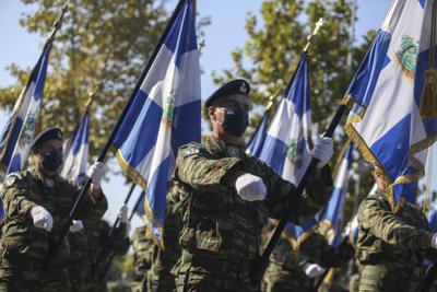 Soldados griegos con banderas desfilan en Salónica, norte de Grecia, jueves 28 de octubre de 2021. En la fecha se conmemora la negativa de Grecia a aliarse con la Italia fascista en 1940. La decisión de enfrentar a un enemigo mucho más fuerte arrastró a Grecia a la Segunda Guerra Mundial y su ocupación brutal por la Alemania nazi. (AP Foto/Giannis Papanikos)