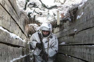 Un soldado armado camina por una trinchera en el territorio controlado por insurgentes prorrusos, en el frente con las líneas gubernamentales ucranianas, cerca de la localidad de Spartak, en el distrito de Yasynuvata de la región de Donetsk, en el este de Ucrania, el 27 de enero de 2022. (AP Foto/Alexei Alexandrov)