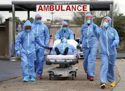 ARCHIVO - Una persona es llevada en una camilla al United Memorial Medical Center después de someterse a pruebas de COVID-19 el jueves 19 de marzo de 2020 en Houston. En el tercer aniversario de la pandemia de COVID-19 en 2023, el virus sigue propagándose y el número de muertos se acerca a los 7 millones en todo el mundo. Sin embargo, la mayoría de las personas han reanudado sus vidas normales, gracias a un muro de inmunidad construido a partir de infecciones y vacunas. (AP Photo/David J. Phillip, Archivo)