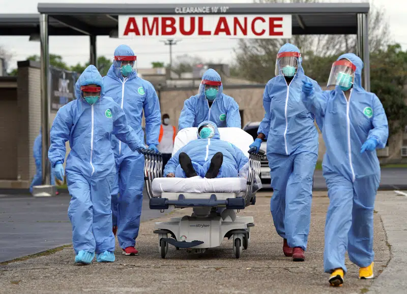 FILE - A person is taken on a stretcher into the United Memorial Medical Center after going through testing for COVID-19 Thursday, March 19, 2020, in Houston. On the third anniversary of the COVID-19 pandemic in 2023, the virus is still spreading and the death toll is nearing 7 million worldwide. Yet most people have resumed their normal lives, thanks to a wall of immunity built from infections and vaccines. (AP Photo/David J. Phillip, File)