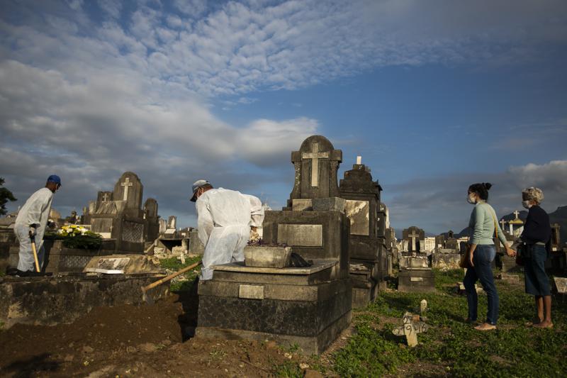 Relatives attend the burial service of 89-year-old Irodina Pinto Ribeiro, who died from COVID-19 related complications, at the Inhauma cemetery in Rio de Janeiro, Brazil, Friday, June 18, 2021. Brazil is approaching an official COVID-19 death toll of 500,000 — second-highest in the world. (AP Photo/Bruna Prado)