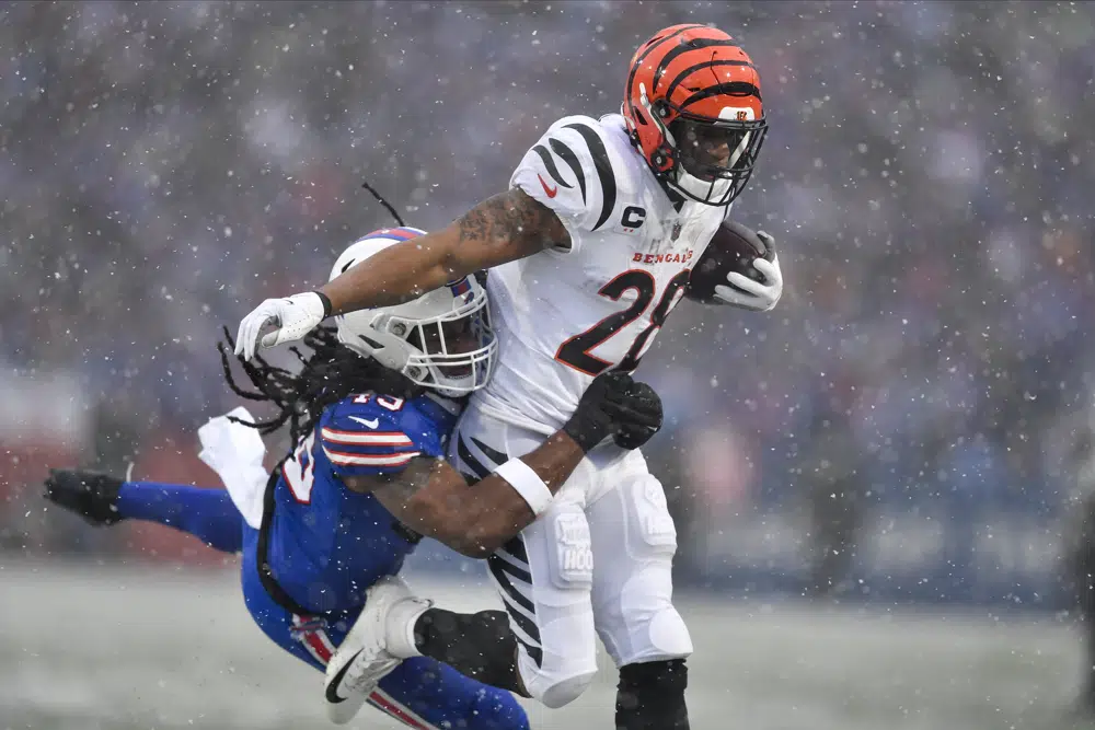 Cincinnati Bengals cornerback Cam Taylor-Britt (29) takes a hit from Buffalo Bills linebacker Tremaine Edmunds (49) during the first quarter of an NFL division round football game, Sunday, Jan. 22, 2023, in Orchard Park, N.Y. (AP Photo/Adrian Kraus)