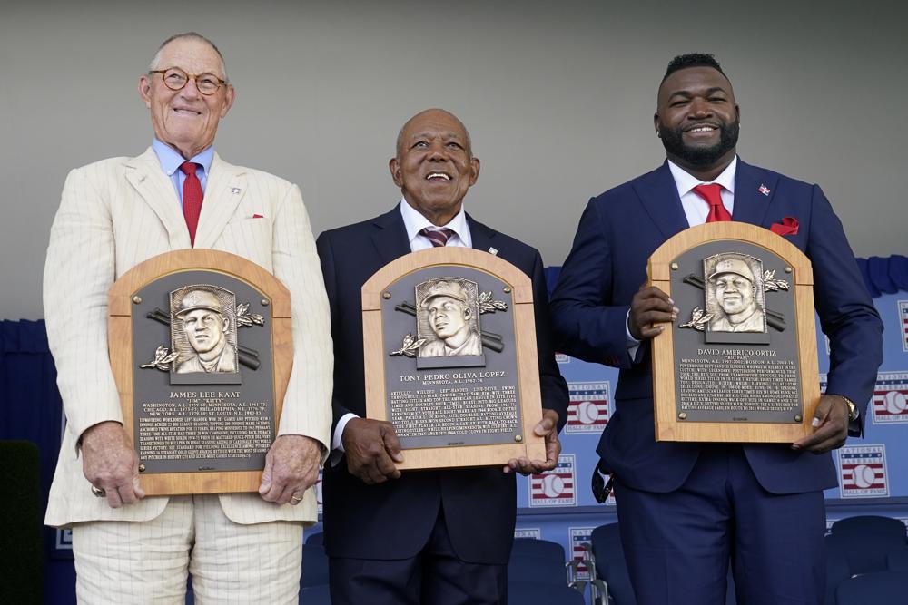 De derecha a izquierda, Jim Kaat, Tony Oliva y David Ortiz muestran sus placas tras ser exaltados al Salón de la Fama, el domingo 24 de julio de 2022, en Cooperstown, Nueva York.  (Foto AP/John Minchillo)