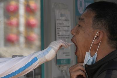 ARCHIVO - Un trabajador toma una muestra para una prueba diagnóstica de COVID-19 el martes 15 de marzo de 2022 en Barijing, China. (AP Photo/Ng Han Guan, Archivo)