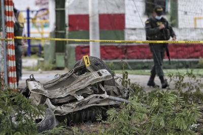 La policía camina cerca de los restos de un coche bomba que explotó cerca de una estación de policía en Padilla, Cauca, Colombia, el domingo 6 de febrero de 2022. (AP Foto/Andrés González)