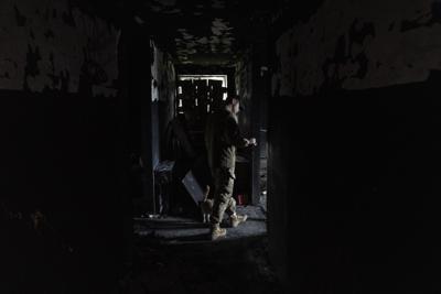El militar ucraniano Anton comprueba un edificio antes empleado por soldados rusos como base temporal en el poblado de Malaya Rohan, en la región de Járkiv, en el este de Ucrania, el 16 de mayo de 2022. (AP Foto/Bernat Armangue)