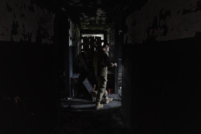 El militar ucraniano Anton comprueba un edificio antes empleado por soldados rusos como base temporal en el poblado de Malaya Rohan, en la región de Járkiv, en el este de Ucrania, el 16 de mayo de 2022. (AP Foto/Bernat Armangue)
