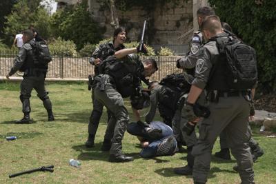 Miembros de las fuerzas de seguridad israelíes detienen a un manifestante palestino cerca de la Puerta de Damasco, frente a la Ciudad Vieja de Jerusalén, mientras los israelíes conmemoran el Día de Jerusalén, una fiesta israelí que celebra la captura de la Ciudad Vieja durante la guerra de Oriente Medio de 1967. Domingo 29 de mayo de 2022. Israel reclama toda Jerusalén como su capital. Pero los palestinos, que buscan a Jerusalén oriental como la capital de un futuro estado, ven la marcha como una provocación. El año pasado, el desfile ayudó a desencadenar una guerra de 11 días entre Israel y los militantes de Gaza. (AP Photo/Mahmoud Illean)