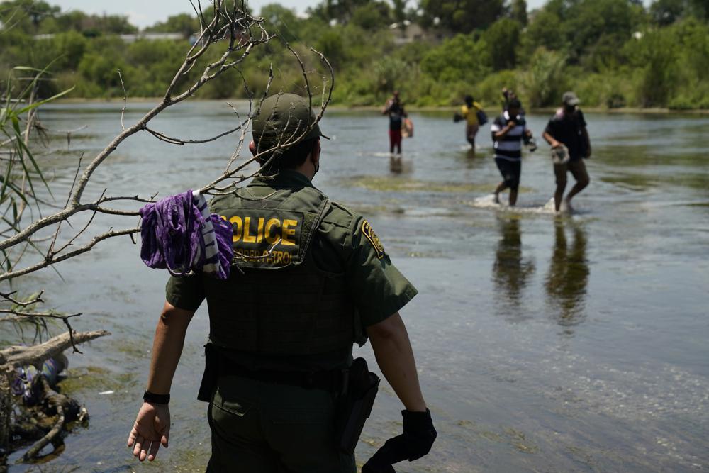 Venezolanos huyendo de la crisis pandémica y la tiranía de Maduro rompen récord en la frontera de EE UU 1 A Border Patrol agent watches as a group of migrants walk across the Rio Grande on their way to turn themselves in upon crossing the U.S.-Mexico border, Tuesday, June 15, 2021, in Del Rio, Texas. U.S. government data shows that 42% of all families encountered along the border in May hailed from places other than Mexico, El Salvador, Guatemala and Honduras — the traditional drivers of migratory trends. (AP Photo/Eric Gay)