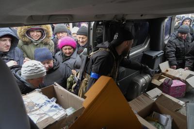Residentes locales reciben ayuda humanitaria de voluntarios el martes 5 de abril de 2022 en Bucha, cerca de Kiev, Ucrania. (AP Foto/Efrem Lukatsky)
