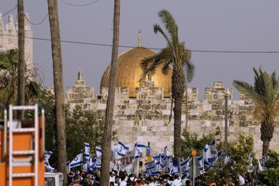 Los israelíes ondean banderas nacionales frente a la Puerta de Damasco fuera de la Ciudad Vieja de Jerusalén para conmemorar el Día de Jerusalén, un día festivo israelí que celebra la captura de la Ciudad Vieja durante la guerra de Medio Oriente de 1967, el domingo 29 de mayo de 2022. Israel reclama toda Jerusalén como su capital. Pero los palestinos, que buscan a Jerusalén oriental como la capital de un futuro estado, ven la marcha como una provocación. El año pasado, el desfile ayudó a desencadenar una guerra de 11 días entre Israel y los militantes de Gaza. (AP Foto/Ariel Schalit)