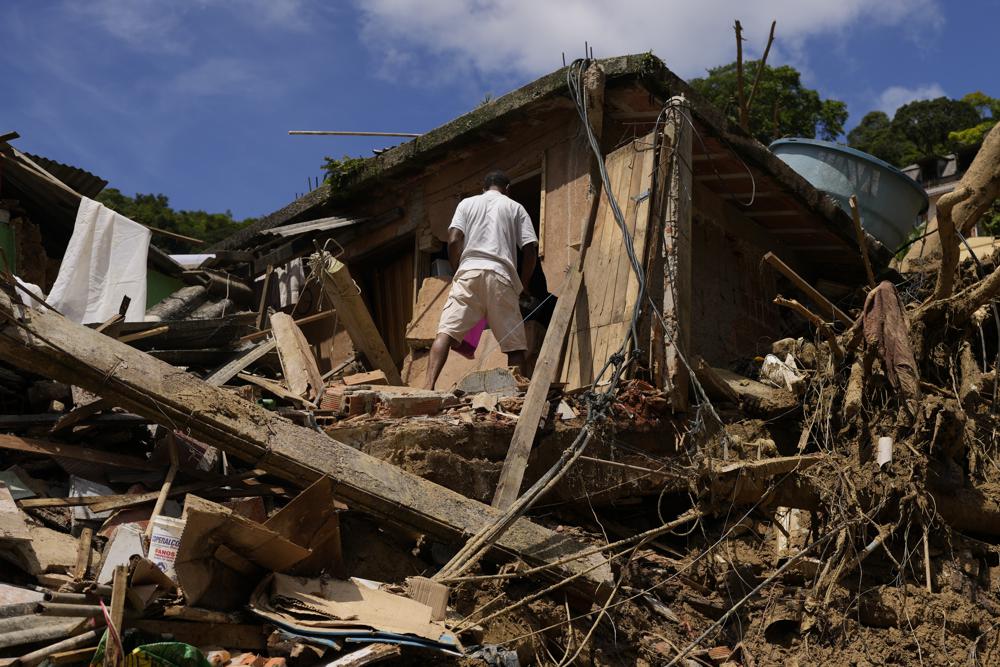 Un residente se encuentra en una propiedad destruida por deslizamientos de tierra en el segundo día de labores de rescate en Petrópolis, Brasil, el jueves 17 de febrero de 2022. no está claro cuántos cuerpos quedaron atrapados en el lodo.  (Foto AP/Silvia Izquierdo)