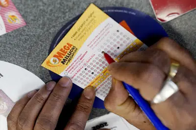 Un cliente llegan un boleto de lotería Mega Millions en una tienda de conveniencia en Northbrook, Illinois, el 6 de enero de 2021. (AP Foto/Nam Y. Huh, Archivo)