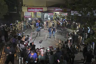 La policía en la zona en que el ex legislador indio Atiq Ahmad y su hermano Ashraf fueron asesinados, en Prayagraj, India, el 15 de abril de 2023. (AP foto/Rajesh Kumar Singh)