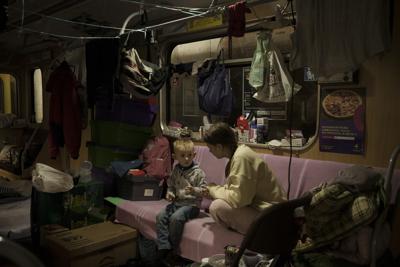 Dos personas permanecen dentro de un vagón del metro estacionado en una estación a la que se emplea como refugio antibombas en medio de la ofensiva rusa en Járkiv, Ucrania, el viernes 25 de marzo de 2022. (AP Foto/Felipe Dana)