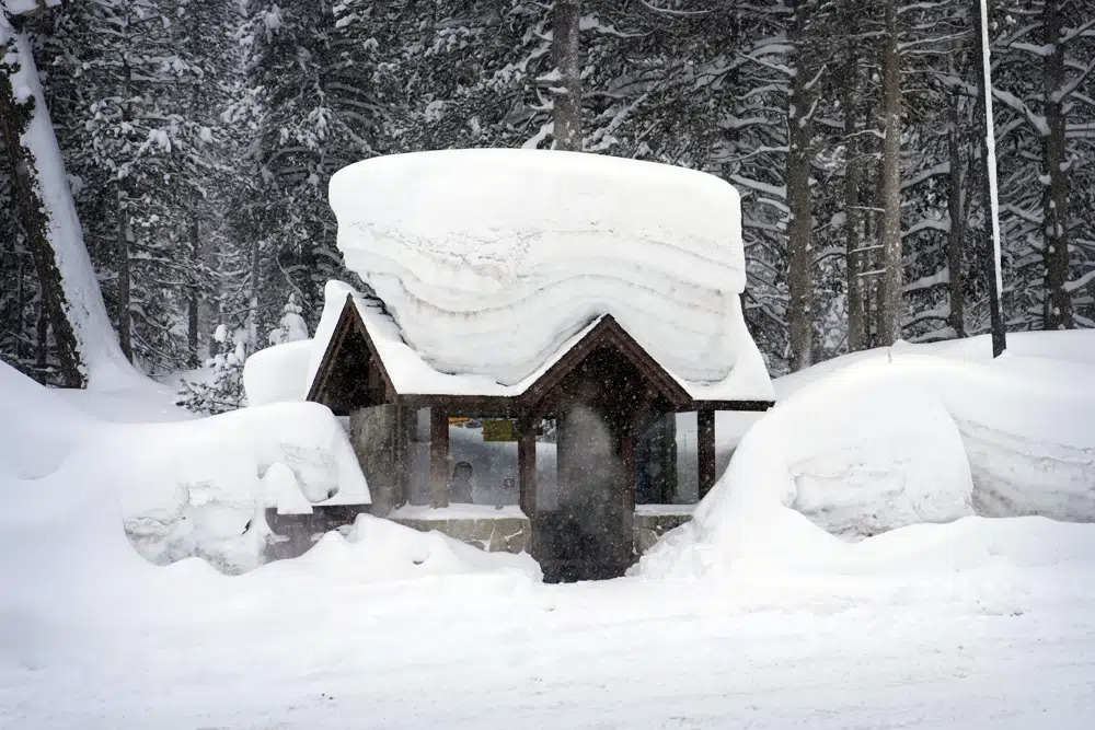 Una persona sentada en una parada de autobús cubierta de nieve el viernes 24 de febrero de 2023 en Olympic Valley, California. California y otras partes del oeste enfrentan fuertes nevadas y lluvias debido a la última tormenta invernal que azota a los Estados Unidos. (Foto AP/John Locher)