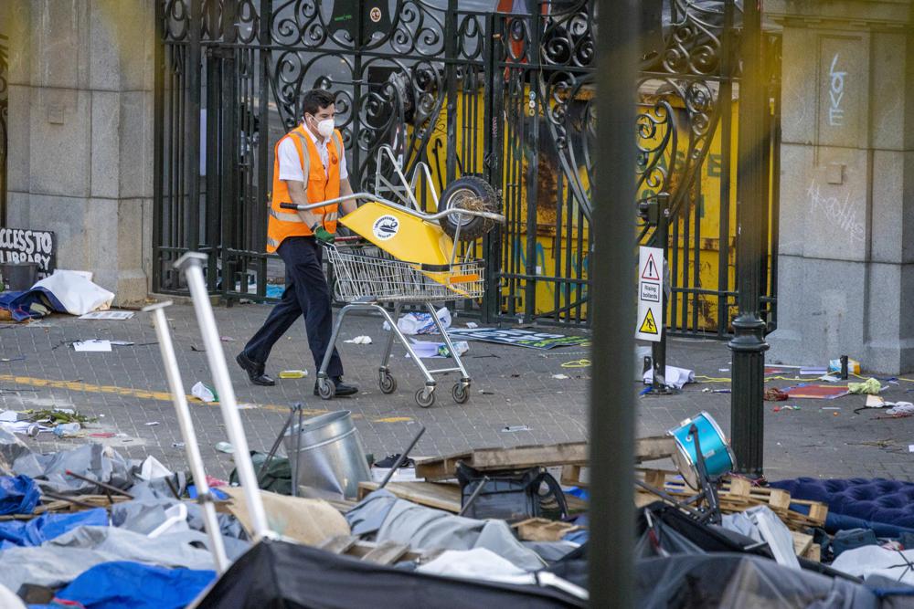 Workers start the clean up of Parliament lawn's following Wednesday's violent end to protests opposing coronavirus vaccine mandates in Wellington, New Zealand, Thursday, March 3, 2022. Since the beginning of the pandemic, New Zealand has reported fewer than 100 virus deaths among its population of 5 million, after it imposed strict border controls and lockdowns to eliminate earlier outbreaks. (Mike Scott/New Zealand Herald via AP)