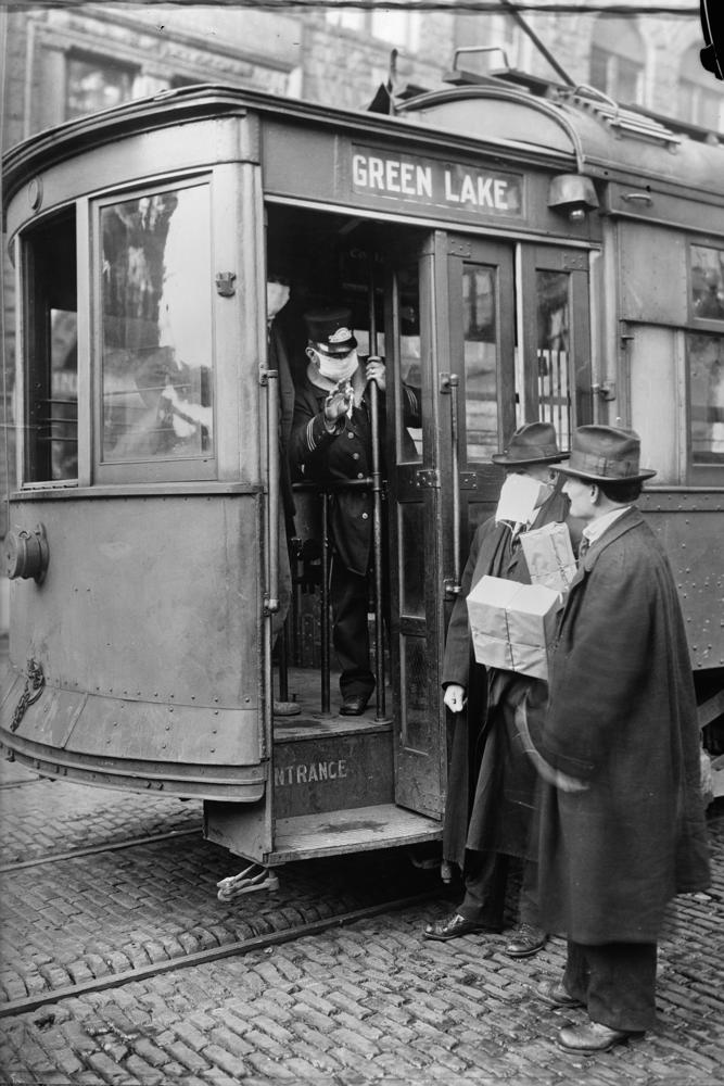 FILE - In this 1918-1919 photo made available by the Library of Congress, a conductor checks to see if potential passengers are wearing masks in Seattle, Wash. During the influenza epidemic, masks were required for all passengers. (Library of Congress via AP, File)