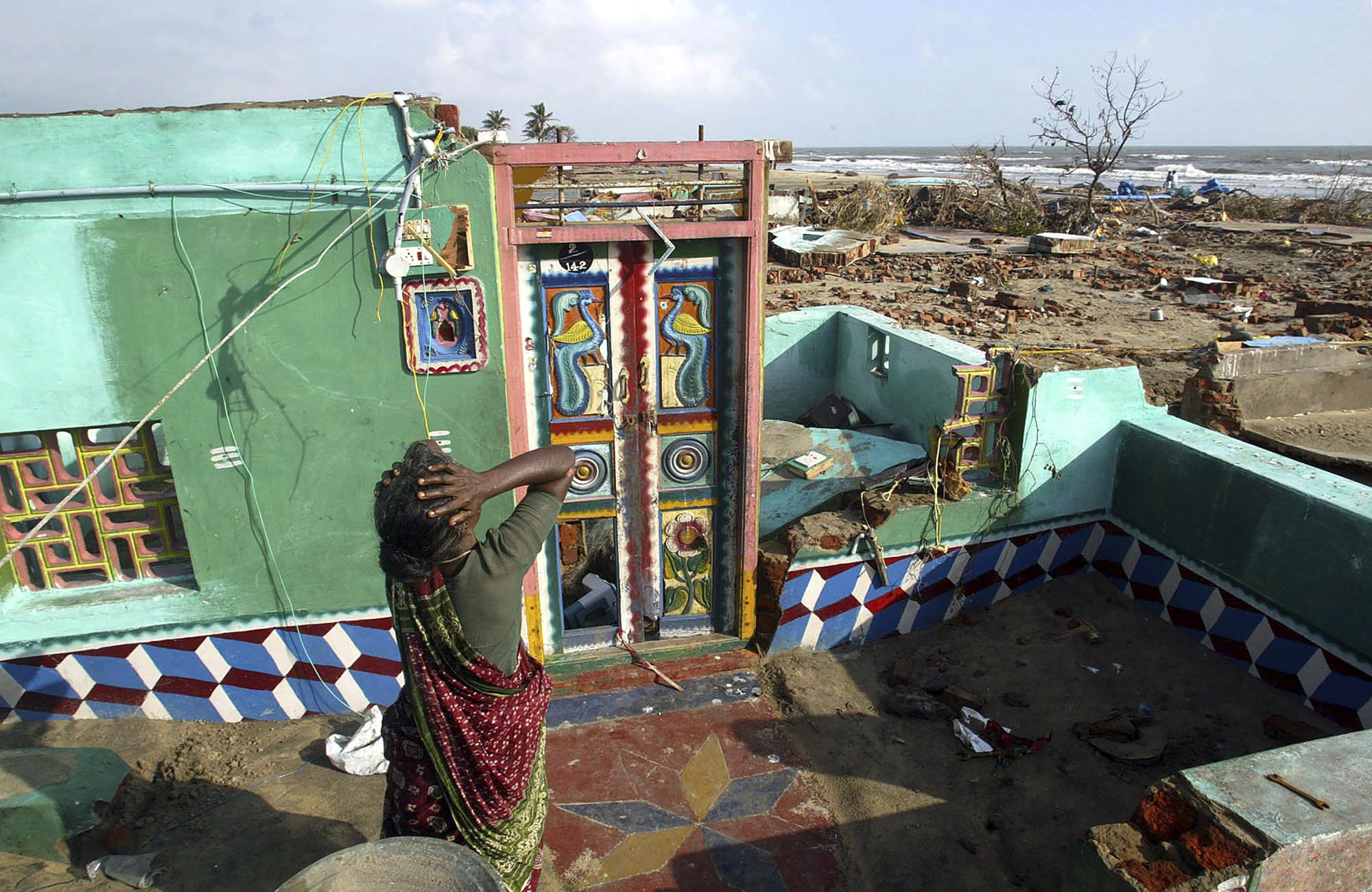 ARQUIVO - Paliyamma lamenta ao retornar para sua casa danificada em uma colônia de pescadores atingida pelo tsunami, em Nagappattinam, no estado de Tamil Nadu, no sul da Índia, em 31 de dezembro de 2004. O enorme tsunami desencadeado por um terremoto submarino no Oceano Índico matou mais de 10.000 índios. Paliyama perdeu sete membros de sua família. (Foto AP/Gurinder Osan, Arquivo)