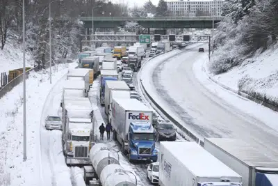 Una enorme hilera de vehículos de todo tipo permanece paralizada en la carretera interestatal 84 debido a la caida de nieve en el noreste de Portland, Oregon, el jueves 23 de febrero de 2023. La imagen fue tomada desde el Puente Blumenauer para Bicicletas y Transeúntes. (Dave Killen /The Oregonian vía AP)