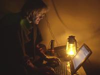 FILE - Associated Press Islamabad bureau chief Kathy Gannon reports from the basement of the AP house in Kabul, Afghanistan, during a night of heavy bombing on Oct. 26. 2001. On Sept. 11, 2001, Gannon, reporting in the Afghan capital, received a call from her boss that changed her world forever. (AP Photo/Dimitri Messinis)