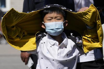 Un niño con mascarilla hace fila para hacer una prueba de COVID-19 el domingo 1 de mayo de 2022 en Beijing, China. (AP Foto/Ng Han Guan)
