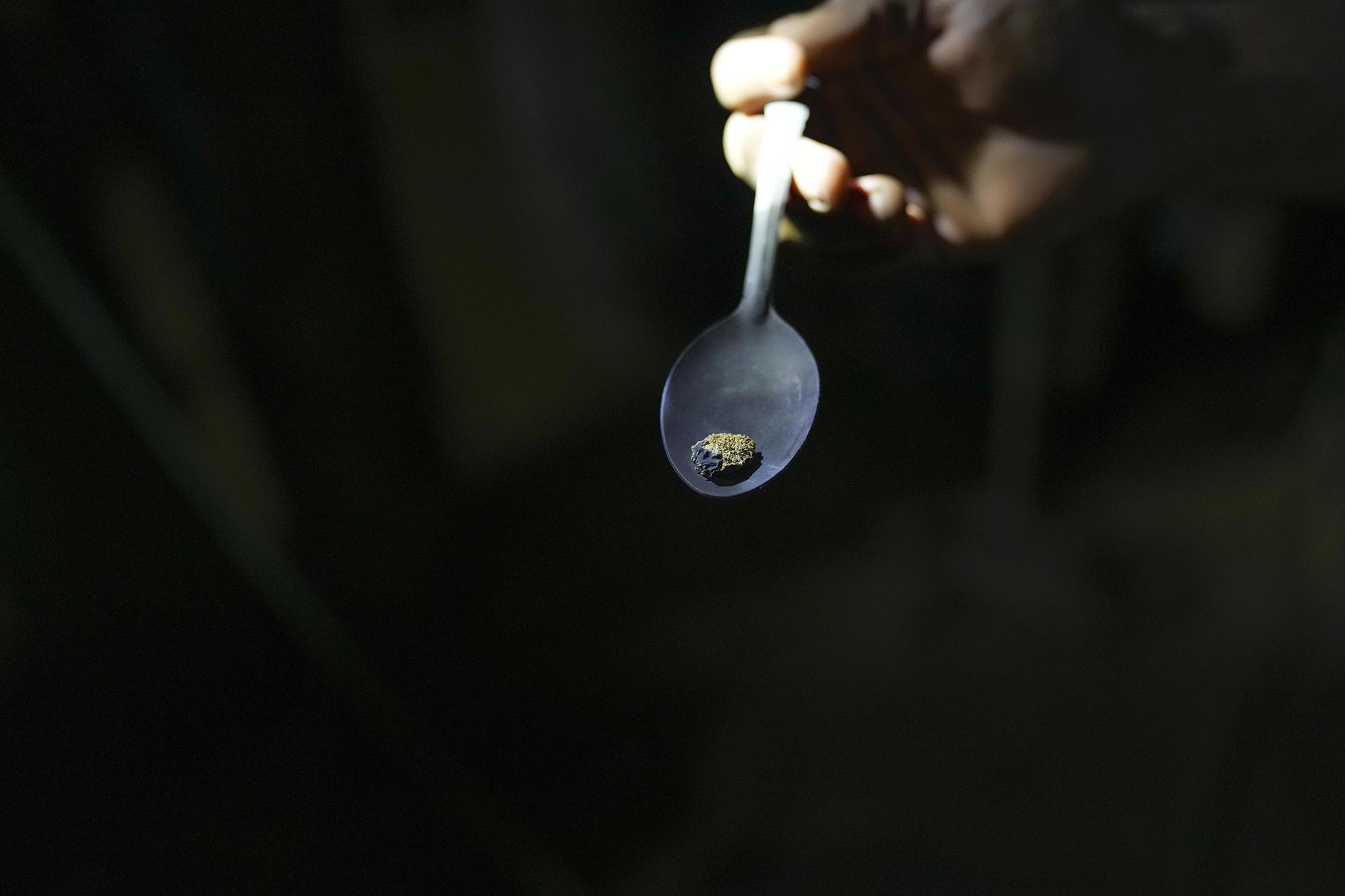 Un trabajador muestra una cuchara de oro después de usar fuego para evaporar el mercurio de una amalgama, en una mina de oro en El Callao, estado de Bolívar, Venezuela, el viernes 28 de abril de 2023. (Foto AP/Matias Delacroix)