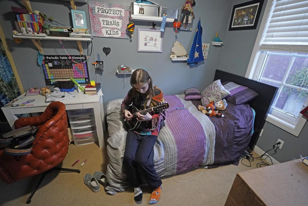 Elle Palmer, 13, plays her mandolin, Monday, Feb. 7, 2023, in Salt Lake City. Elle remembers her first day at the school after she transferred. Before leaving, she came downstairs in rainbow sparkle-embroidered cowboy boots her mother worried would only spur bullies. Taunts from kids at Elle’s prior school drove her into depression so deep she had suicidal thoughts. (AP Photo/Rick Bowmer)