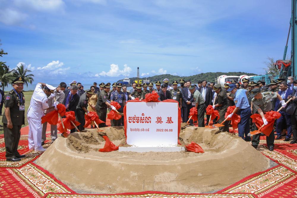 In this photo provided by Cambodia's Fresh News, Cambodian Defense Minister Tea Banh, rear center left, and Chinese Ambassador to Cambodia Wang Wentian, rear center right, preside over the groundbreaking ceremony for a shipyard repairing and restoration workshop in Ream Cambodian Naval Base of Sihanoukville, Wednesday, June 8, 2022. Chinese and Cambodian officials broke ground Wednesday on a naval port expansion project, dismissing American concerns it could provide Beijing with a strategically important outpost on the Gulf of Thailand. (Cambodia's Fresh News via AP)