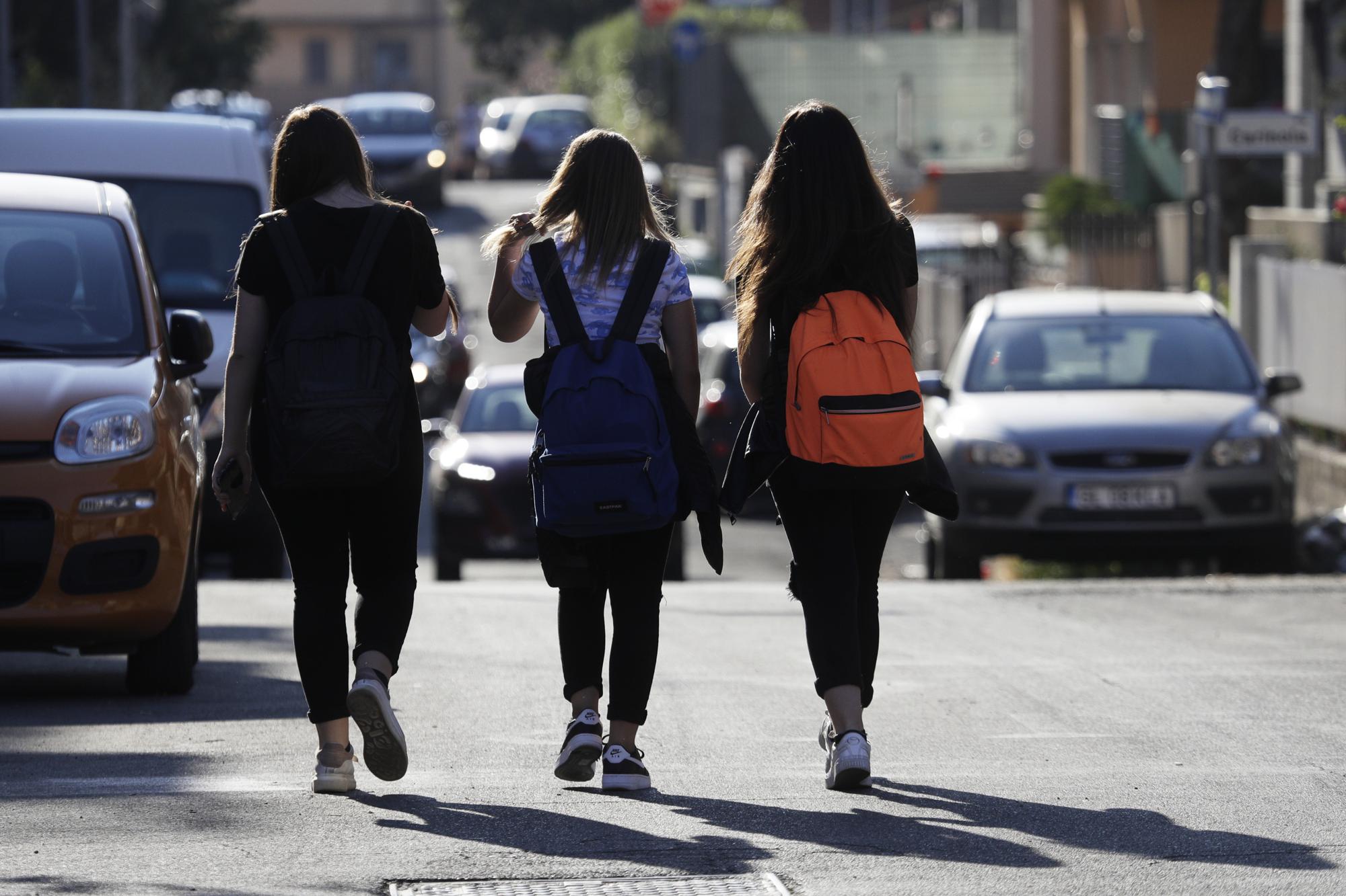 Elena Maria Moretti, 12, center, walks with her friends to school in Rome, Thursday, June 3, 2021. The joy of rejoining the world -- and especially reuniting with friends and extended family -- has been a universal theme for the young participants who've been able to do so. "Being with them, hugging them," Moretti says. (AP Photo/Gregorio Borgia)