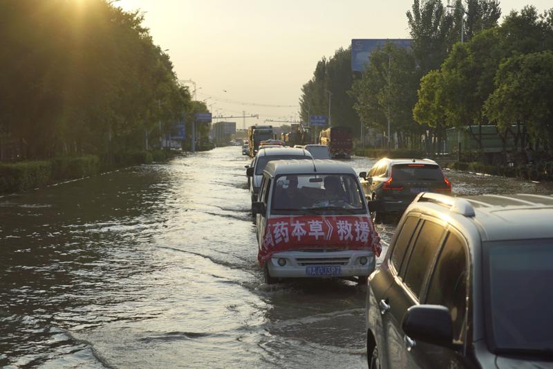 Vehicles, some ferrying supplies, arrive in Xinxiang in central China's Henan province on Sunday, July 25, 2021. Trucks carrying water and food on Sunday streamed into the Chinese city at the center of flooding that killed dozens of people, while soldiers laid sandbags to fill gaps in river dikes that left neighborhoods under water. (AP Photo/Dake Kang)