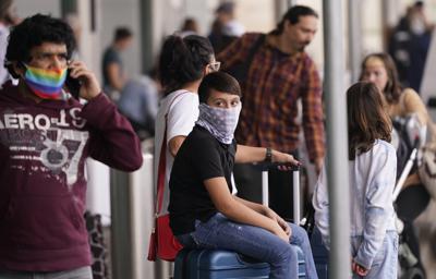 Viajeros usan mascarillas como medida de prevención contra el contagio de coronavirus en el aeropuerto Love Field, en Dallas, el viernes 31 de diciembre de 2021. (AP Foto / LM Otero)