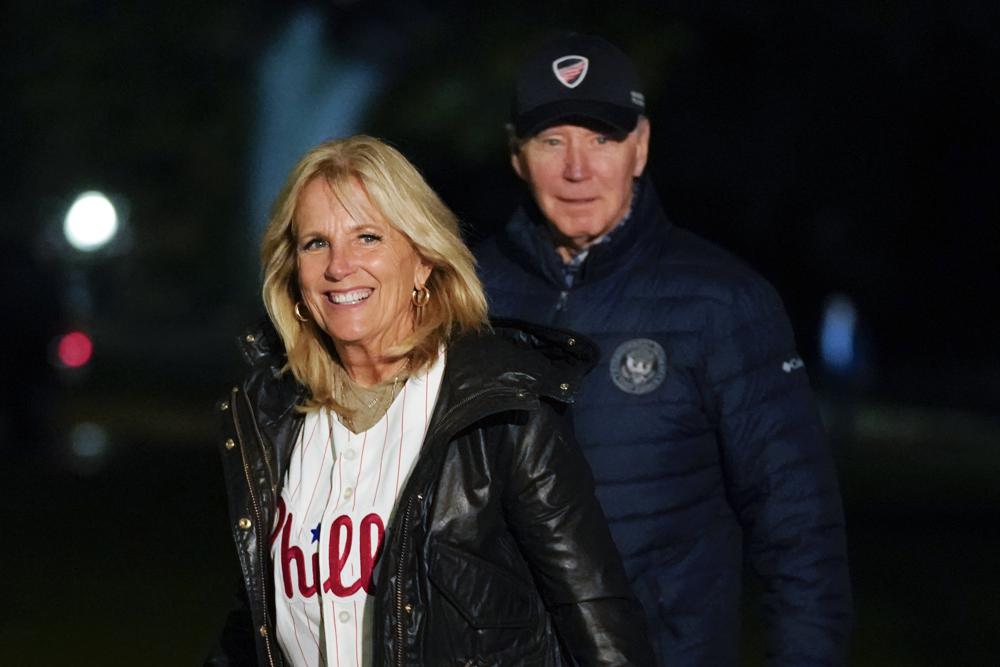 FILE - First lady Jill Biden wears a Philadelphia Phillies jersey as she and President Joe Biden walk on the South Lawn of the White House after stepping off Marine One, Oct. 23, 2022, in Washington. The first lady will attend Game Four of the World Series between the Phillies and the Houston Astros on Tuesday, Nov. 1. (AP Photo/Patrick Semansky, File)