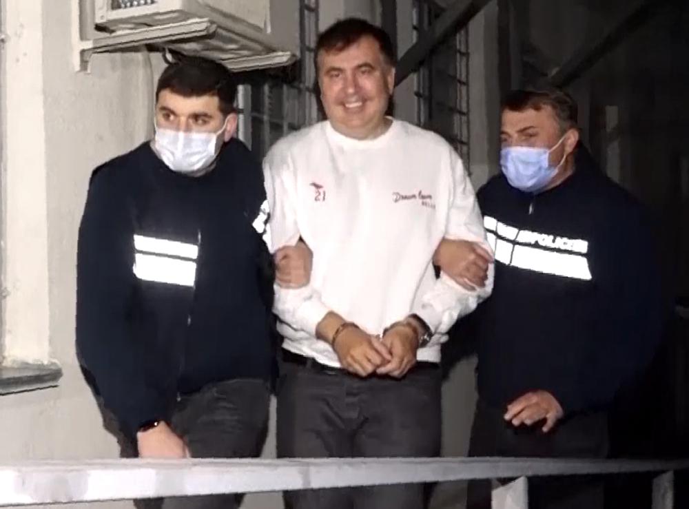 In this handout photo taken from video released by Georgian Interior Ministry Press Service, Georgian Police officers escort former President Mikheil Saakashvili after he was arrested in Rustavi, Georgia, Friday, Oct. 1, 2021. The prime minister of Georgia says former President Mikheil Saakashvili has been arrested. The announcement Friday by Prime Minister Irakli Garibashvili came about 18 hours after Saakashvili, who was convicted in absentia and has lived in Ukraine in recent years, posted on Facebook that he had returned to the country. (Georgian Interior Ministry Press Service via AP) In this handout photo taken from video released by Georgian Interior Ministry Press Service, Georgian Police officers escort former President Mikheil Saakashvili after he was arrested in Rustavi, Georgia, Friday, Oct. 1, 2021. The prime minister of Georgia says former President Mikheil Saakashvili has been arrested. The announcement Friday by Prime Minister Irakli Garibashvili came about 18 hours after Saakashvili, who was convicted in absentia and has lived in Ukraine in recent years, posted on Facebook that he had returned to the country. (Georgian Interior Ministry Press Service via AP)
